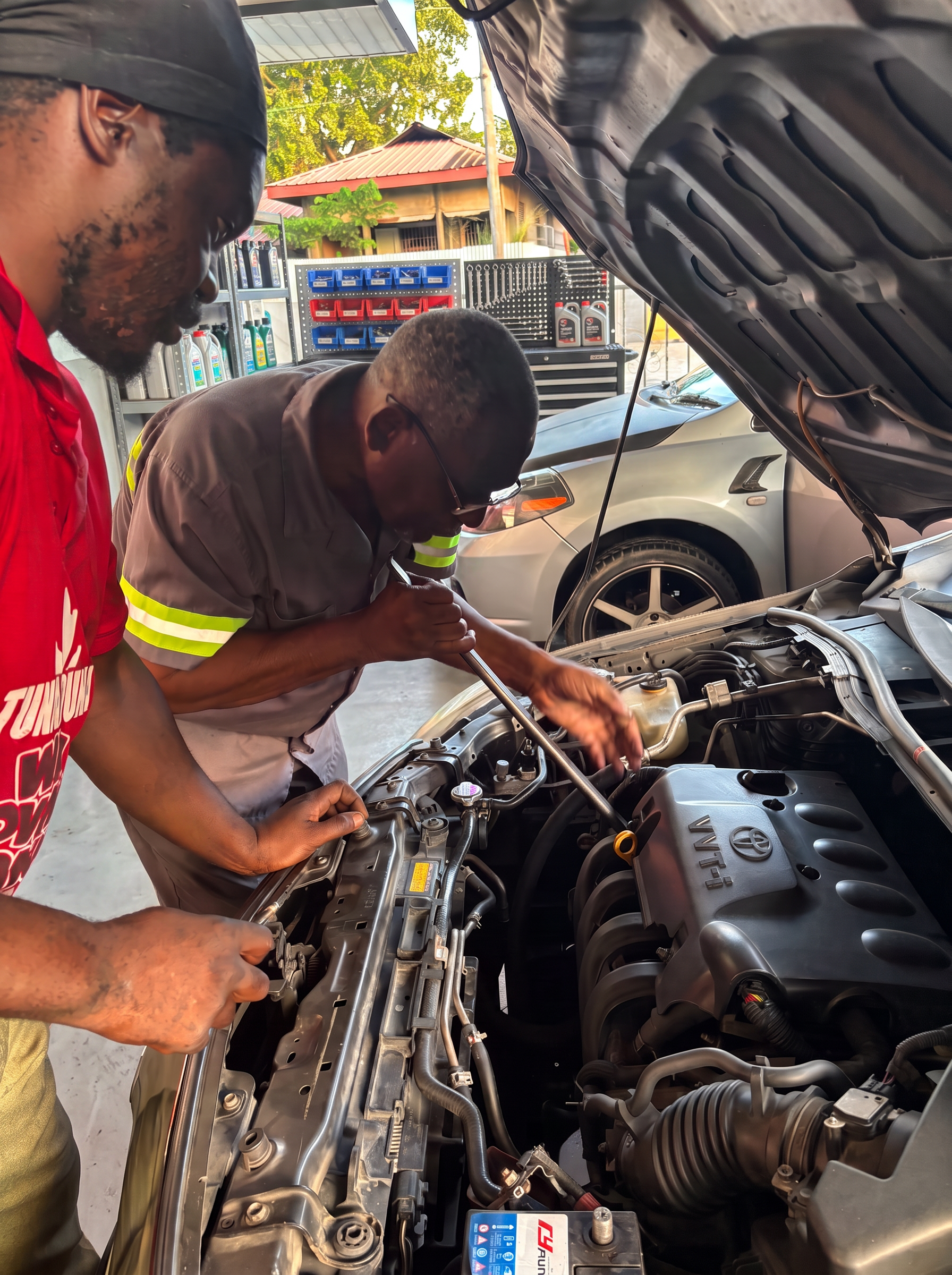 Oscar Gooding guiding a trainee technician while working on a Toyota engine